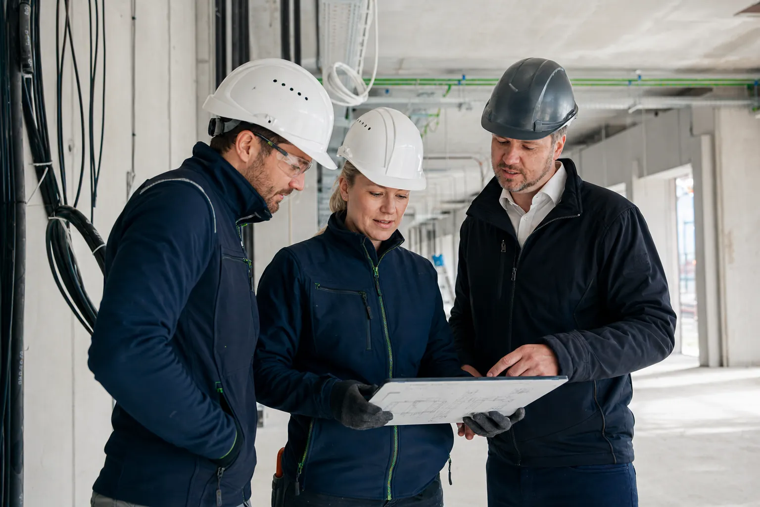 Elektriciens en projectleider stemmen de werkzaamheden samen af